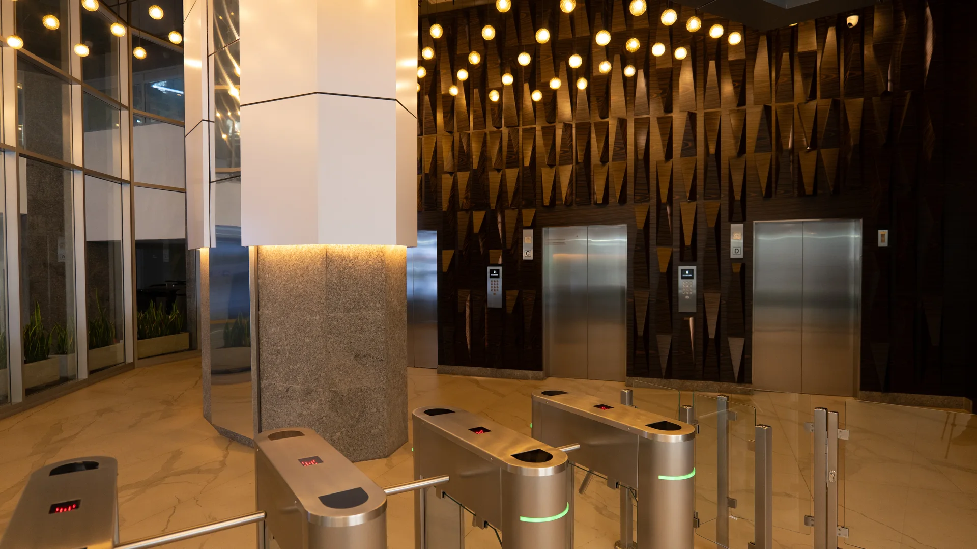 Lobby de Torre 302 con luminarias suspendidas y superficies reflectantes