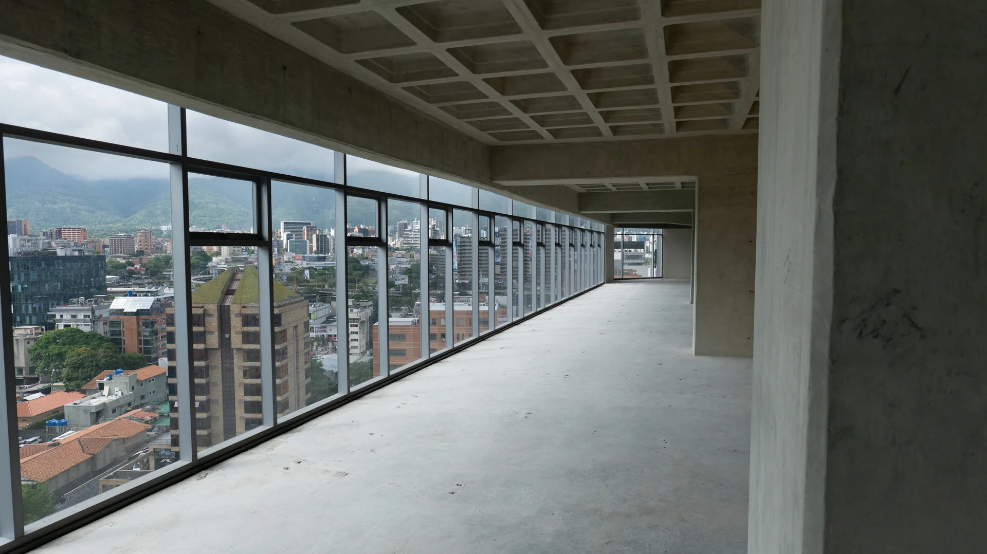 Planta de oficinas sin acondicionar con ventanales y vista al Ávila